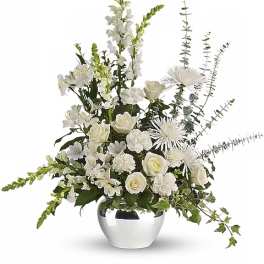 White floral arrangement in a silver vase with tall spiky blooms