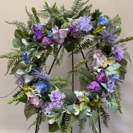 Purple and blue floral wreath with butterflies on a stand
