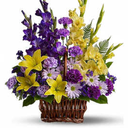 Basket arrangement of purple, yellow, and lavender flowers