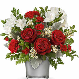Red roses and white flowers arranged in a gray glass vase