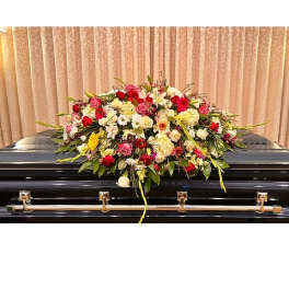Large floral spray on a black casket with red, pink, and white blooms