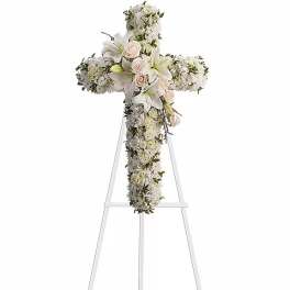White floral cross arrangement on a standing easel