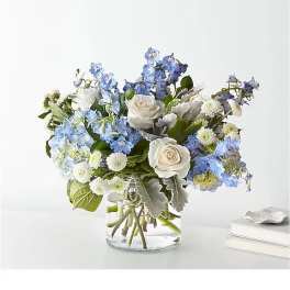 Blue and white flower arrangement in a clear glass vase