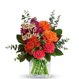 Birthday bouquet with orange and pink flowers in a glass vase