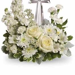 White floral arrangement with a silver cross centerpiece