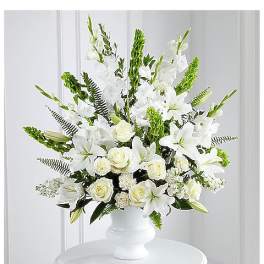White lilies and roses arranged in a white vase