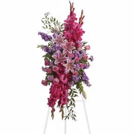 Tall pink and purple floral spray on a white stand