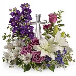 Purple and white floral arrangement with roses and lilies around a silver ribbon