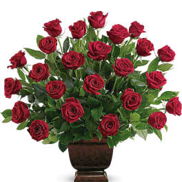 Red roses arranged in a dark urn vase
