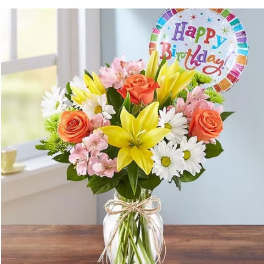 Mixed bouquet in a glass vase with a birthday balloon