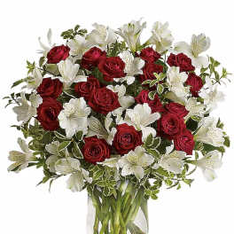 Red roses and white alstroemeria in a clear glass vase