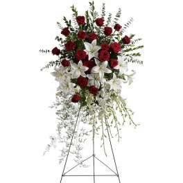 Standing spray of red roses and white lilies on an easel