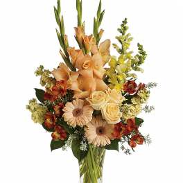 Peach and cream mixed flower arrangement in a clear glass vase