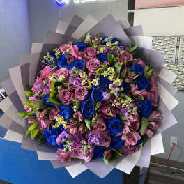 Large bouquet of pink and blue roses with small white filler flowers