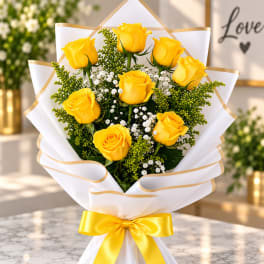 Bouquet of yellow roses wrapped in white paper with a yellow ribbon