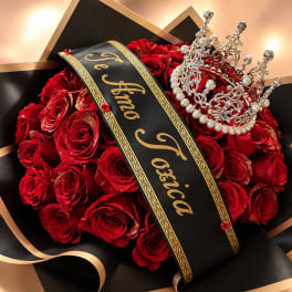 Red roses arranged with a black ribbon and jeweled crown
