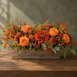 Orange roses and mums arranged in a rustic wooden box
