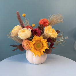 Mixed bouquet with sunflowers, roses, and dahlias in a white vase