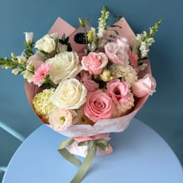 Pink and white mixed flower bouquet wrapped in pastel paper
