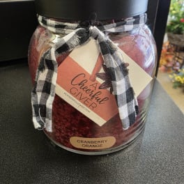 Jar candle with a black-and-white ribbon and cranberry orange label