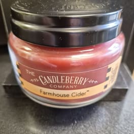 A jar candle labeled Farmhouse Cider from The Candleberry Company