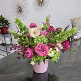 Pink and white floral arrangement in a pink vase