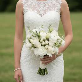 Bride holding a white bouquet with roses and ranunculus