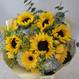 Bouquet of sunflowers with yellow roses and blue hydrangeas