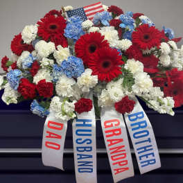 Red, white, and blue floral arrangement with ribbons labeled Dad, Husband, Grandpa, and Brother