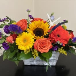 Colorful mixed bouquet in a rustic white wooden container