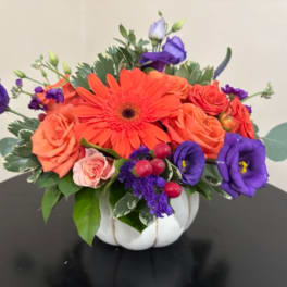 Bright mixed bouquet in a white pumpkin vase