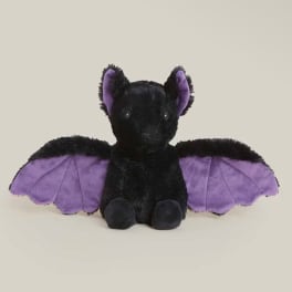 Black bat plush toy with purple wings on a plain background