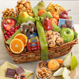 Gift basket with fruit, chocolates, and snacks tied with a green ribbon