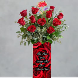 Red roses in a tall vase with a printed love message