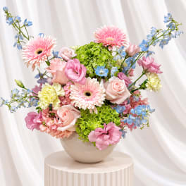 Pink and blue mixed bouquet in a round vase