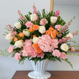 Pink and white floral arrangement in a white vase