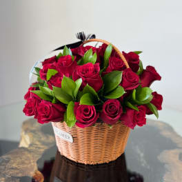 Basket of red roses with green foliage