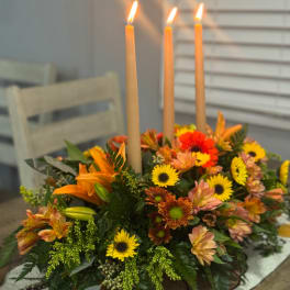 Autumn floral centerpiece with three tall candles