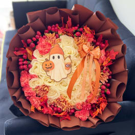 Autumn bouquet of cream roses and pink flowers with a Halloween ghost topper