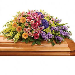 Colorful floral spray on a wooden casket