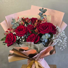 Bouquet of red roses with baby’s breath and pink wrapping