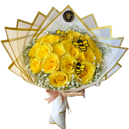 Yellow roses wrapped in white and gold paper with bee decorations