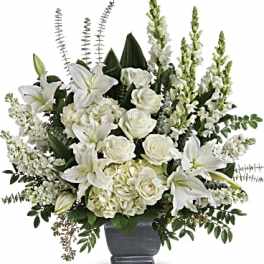 White lilies and roses arranged in a gray urn vase