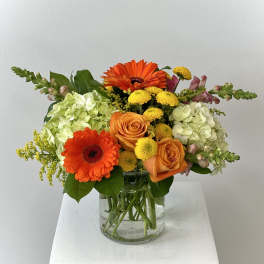 Orange and yellow mixed bouquet in a clear glass vase