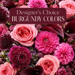 Burgundy and pink floral arrangement with roses, dahlias, and calla lilies