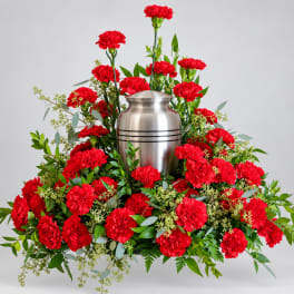 Red carnations arranged around a silver urn
