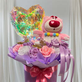 Pink teddy bear in a purple gift box with satin roses and a holographic heart
