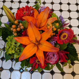 Bright mixed bouquet with orange lilies and red flowers