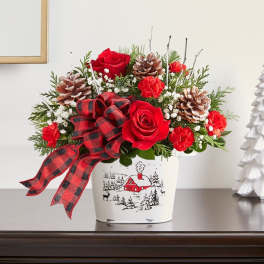 Red roses and carnations in a holiday tin with a plaid ribbon
