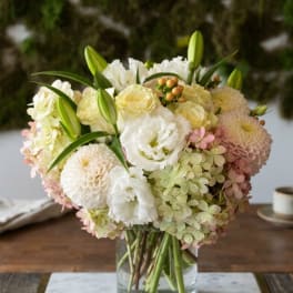 Cream and blush flower bouquet in a clear glass vase